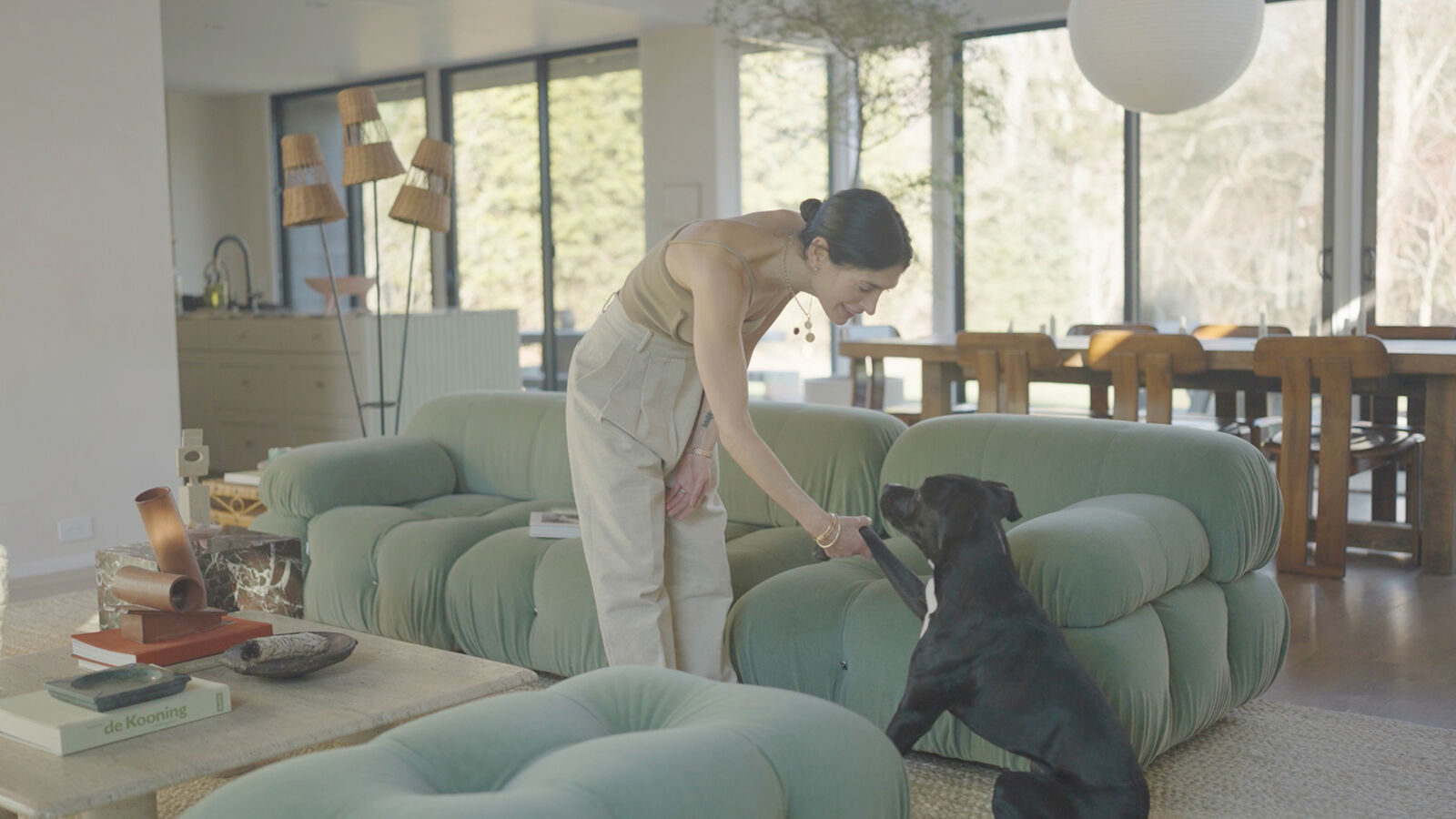 Athena Calderone stroking her dog in a living room with a Camaleonda